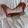 A glass sculpture of a person sitting on top of a bed.