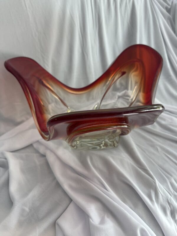 A glass sculpture of a person sitting on top of a bed.