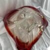 A red and white glass bowl sitting on top of a table.