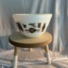 A bowl sitting on top of a wooden stool.