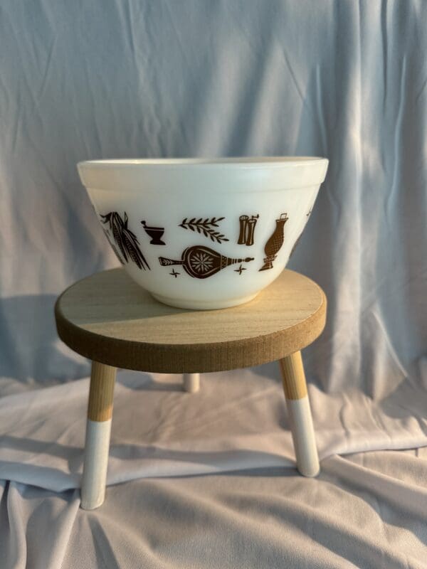 A bowl sitting on top of a wooden stool.