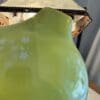 A close up of the top of a green vase