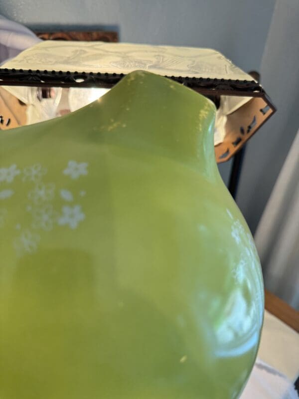 A close up of the top of a green vase