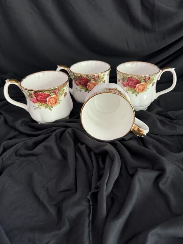 Four cups are sitting on a black cloth.