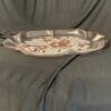 A silver tray with flowers on it sitting on top of the couch.