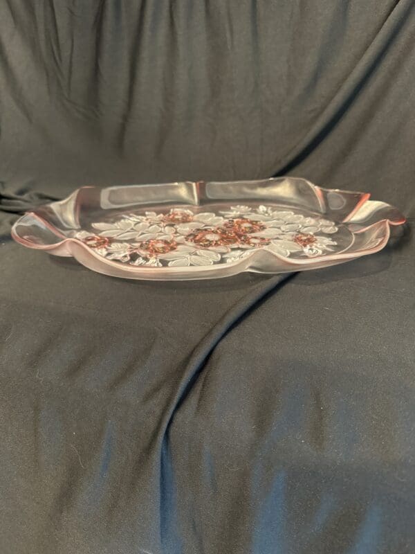 A silver tray with flowers on it sitting on top of the couch.