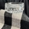 A glass bowl sitting on top of a black and white checkered blanket.