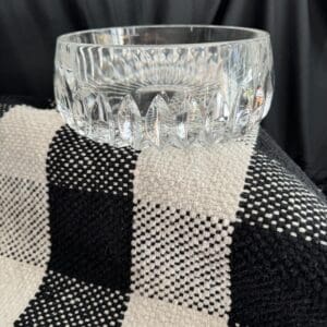 A glass bowl sitting on top of a black and white checkered blanket.