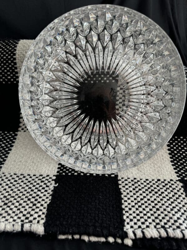 A glass bowl sitting on top of a checkered rug.