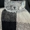 A glass bowl sitting on top of a black and white cloth.