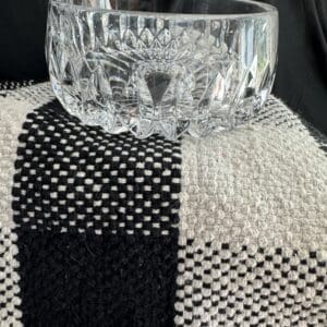 A glass bowl sitting on top of a black and white cloth.