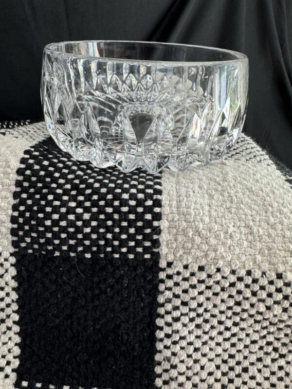 A glass bowl sitting on top of a black and white cloth.