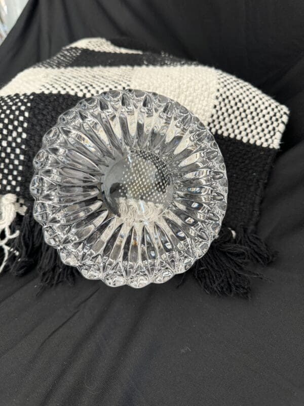 A glass plate sitting on top of a black and white blanket.