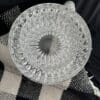 A glass bowl sitting on top of a black and white checkered blanket.