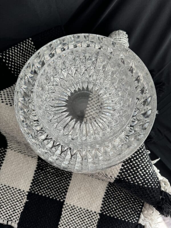 A glass bowl sitting on top of a black and white checkered blanket.