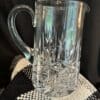 A clear glass pitcher sitting on top of a table.