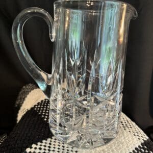 A clear glass pitcher sitting on top of a table.