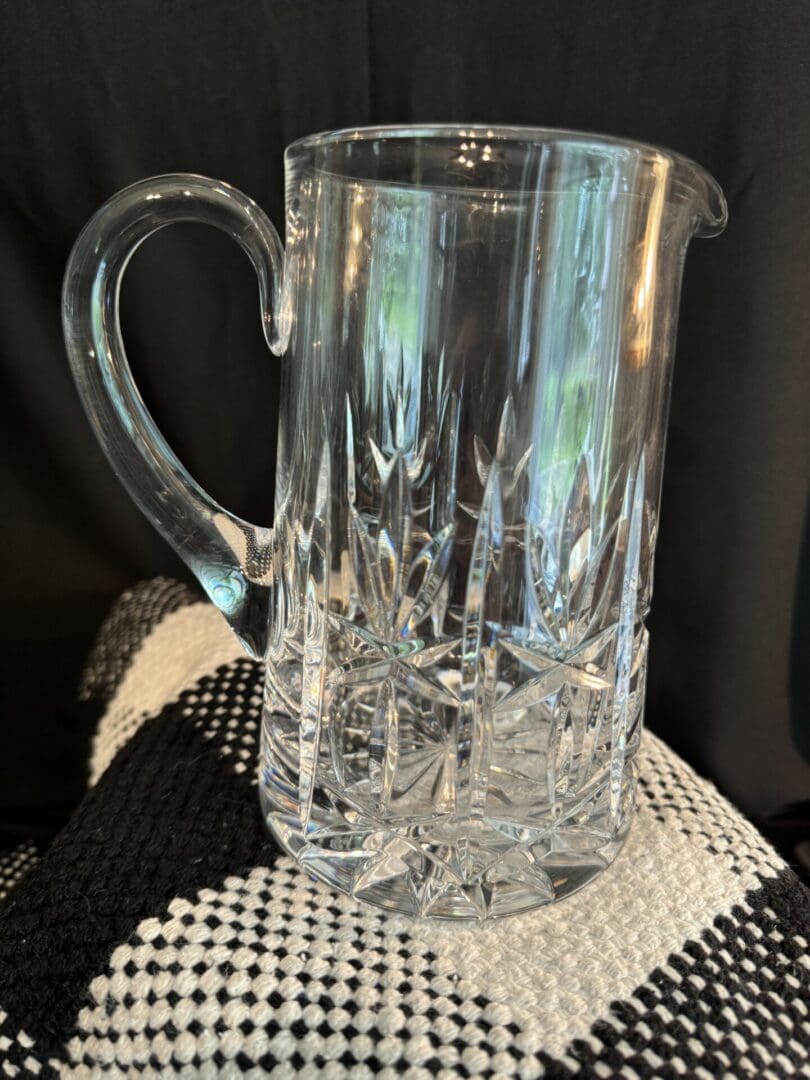 A clear glass pitcher sitting on top of a table.