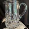 A glass pitcher sitting on top of a table.