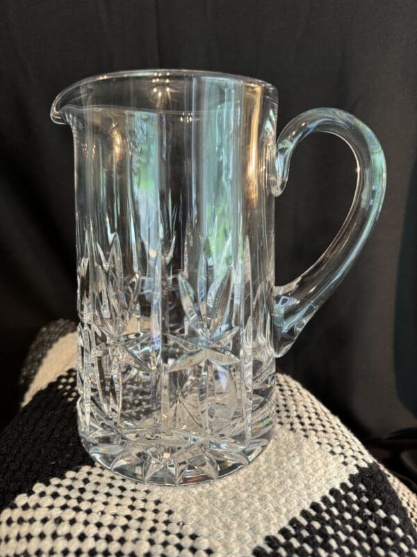 A glass pitcher sitting on top of a table.