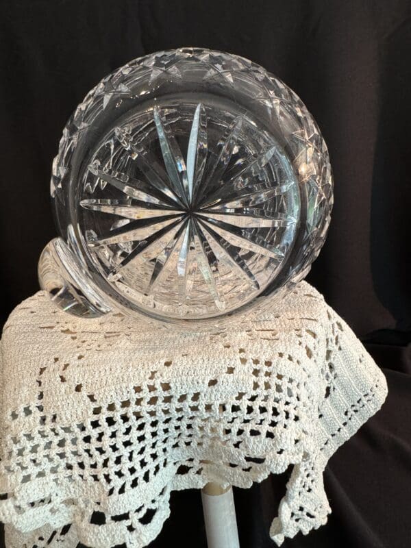 A glass bowl sitting on top of a crocheted doily.