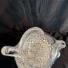 A silver pot sitting on top of a table.