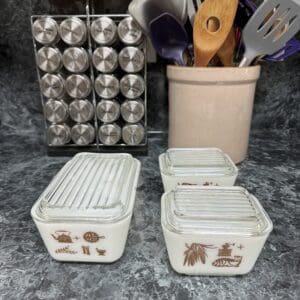 A counter with two containers and utensils in it.