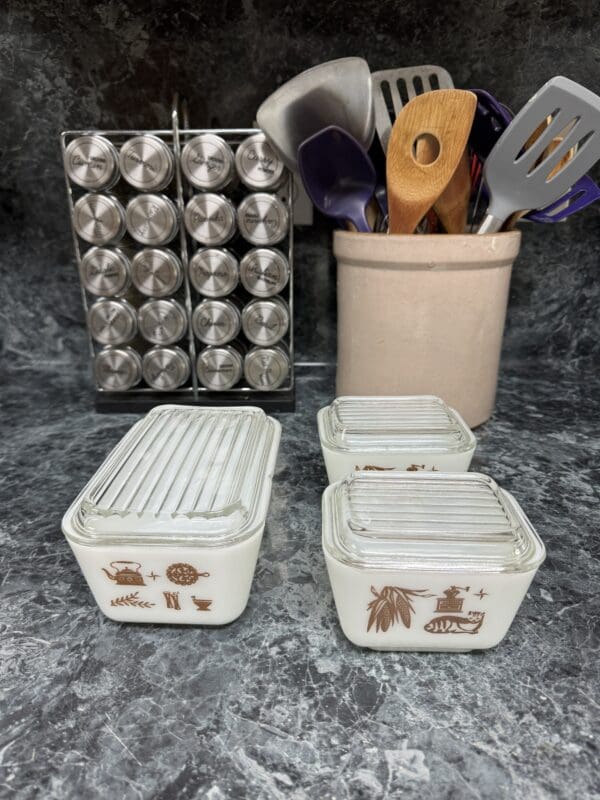 A counter with two containers and utensils in it.