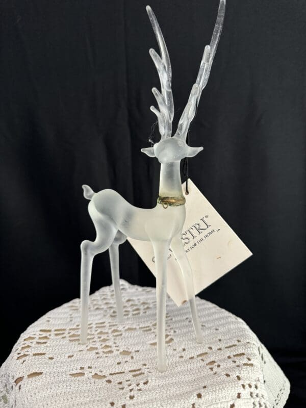 A glass deer with antlers on top of a table.