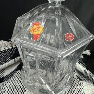 A clear glass container with a lid on top of a table.