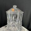 A glass container with a lid on top of a table.