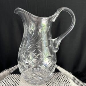 A clear glass pitcher sitting on top of a table.