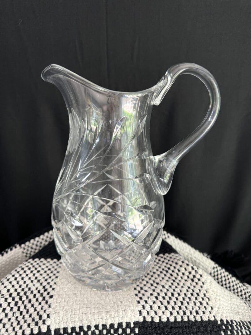 A clear glass pitcher sitting on top of a table.