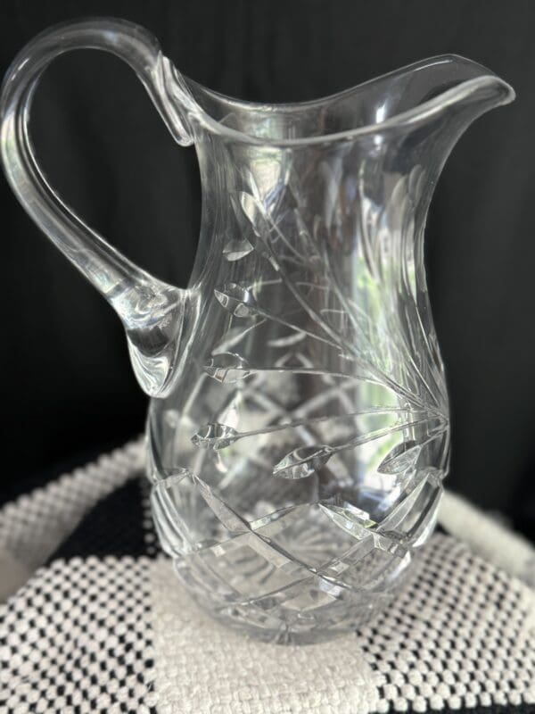 A clear glass pitcher sitting on top of a table.