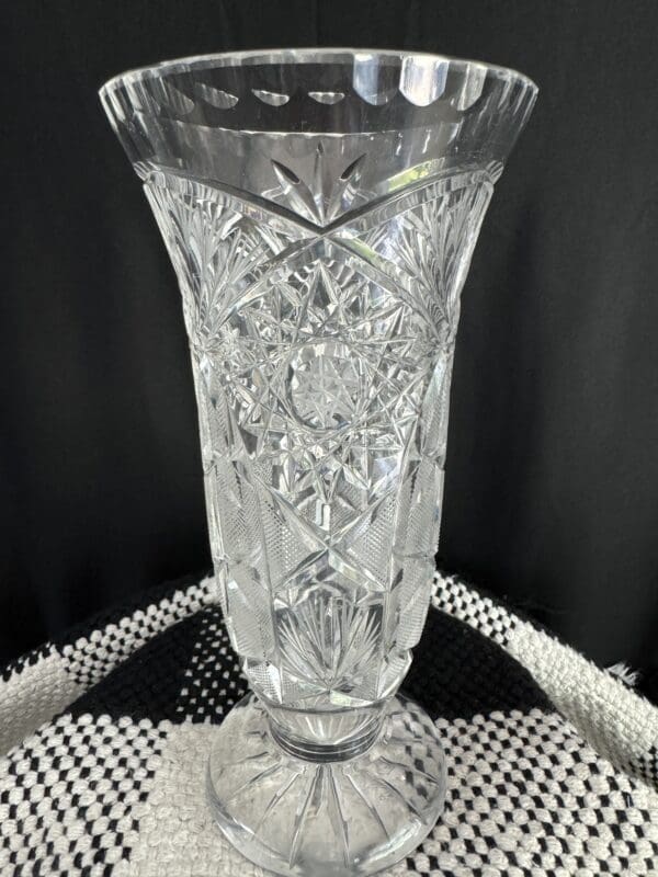 A tall glass vase sitting on top of a table.