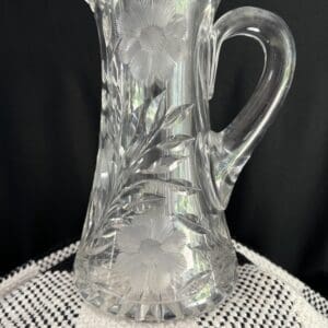 A clear glass pitcher sitting on top of a table.