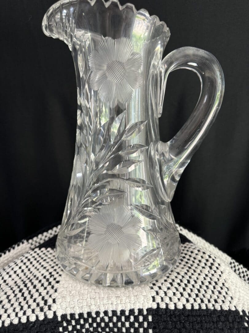 A clear glass pitcher sitting on top of a table.