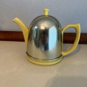 Yellow and silver teapot on a countertop.