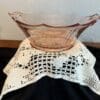 Glass bowl on a lace tablecloth.